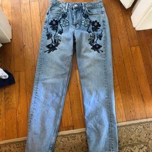 Blue mom jeans with flower embroidery.